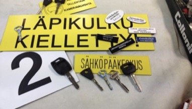 Kaiverrettuja kylttejä ja avaimia työpöydällä